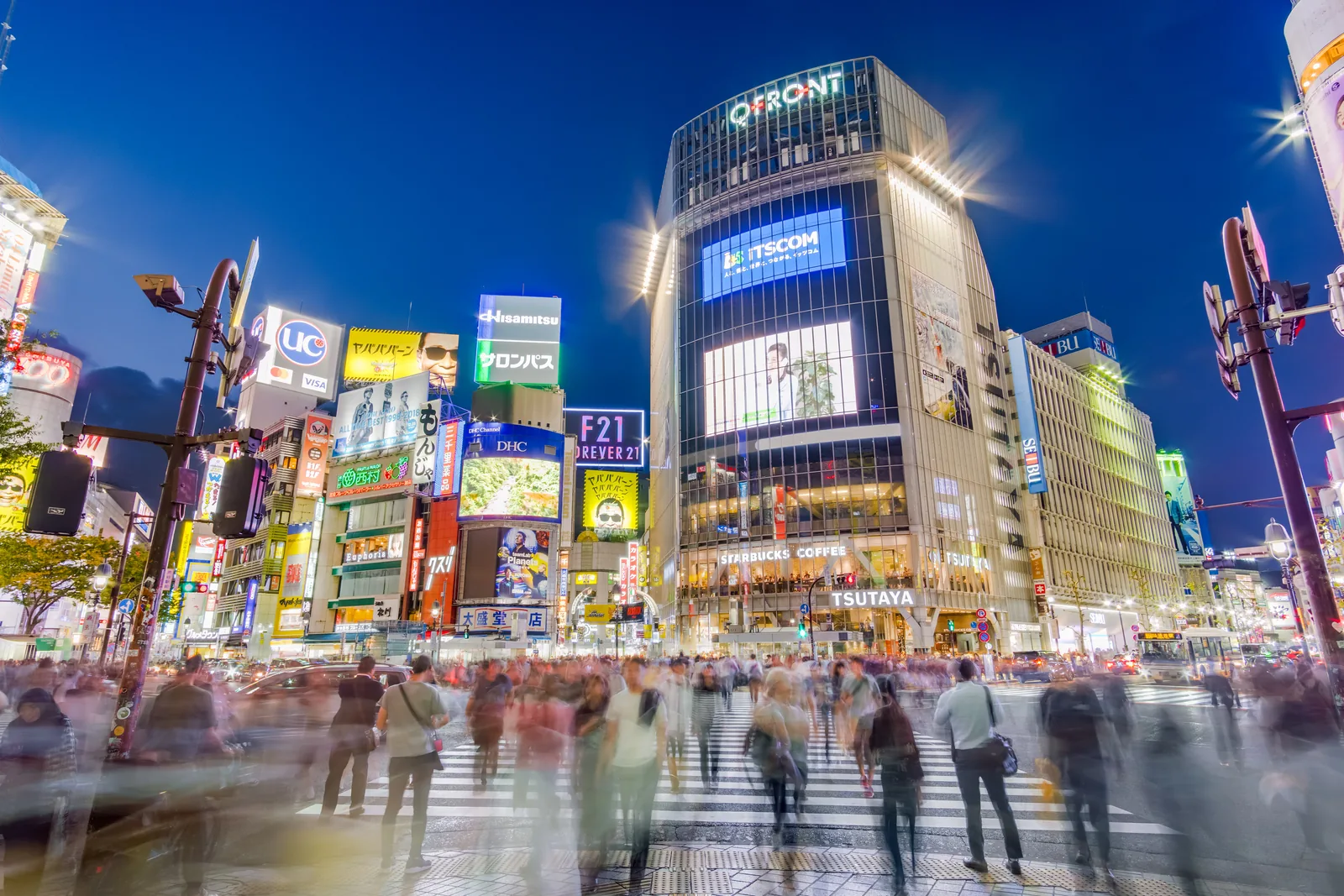 Menschenmengen überqueren die Shibuya-Kreuzung in Tokyo